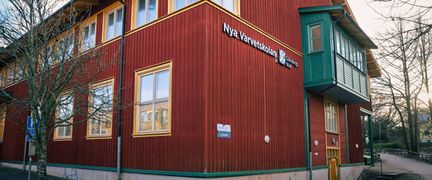 Överblick av Nya Varvetskolan med huvudbyggnaden i fokus och några träd i bakgrunden.