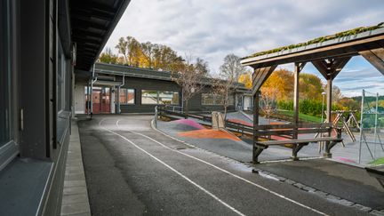Huvudbyggnaden för Hultskolan med skolgården i bakgrunden.