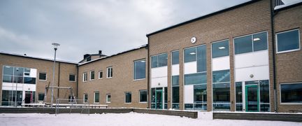 En fotbollsplan utanför Kärraskolan med några ingångar till skolan i bakgrunden.