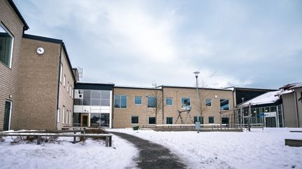 Kärraskolans huvudbyggnader med några bänkar och en lekplats i bakgrunden.