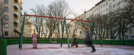 Några barn som gungar och springer på en skolgård
