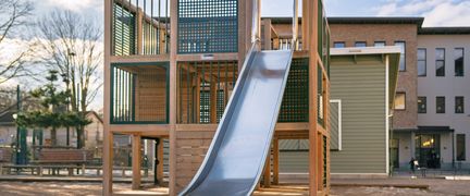 En skolgård med en lekställning med en rutschkana i.