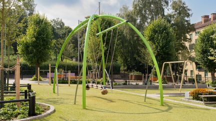 Ett par gungor utanför Ånässkolan med en park i bakgrunden.