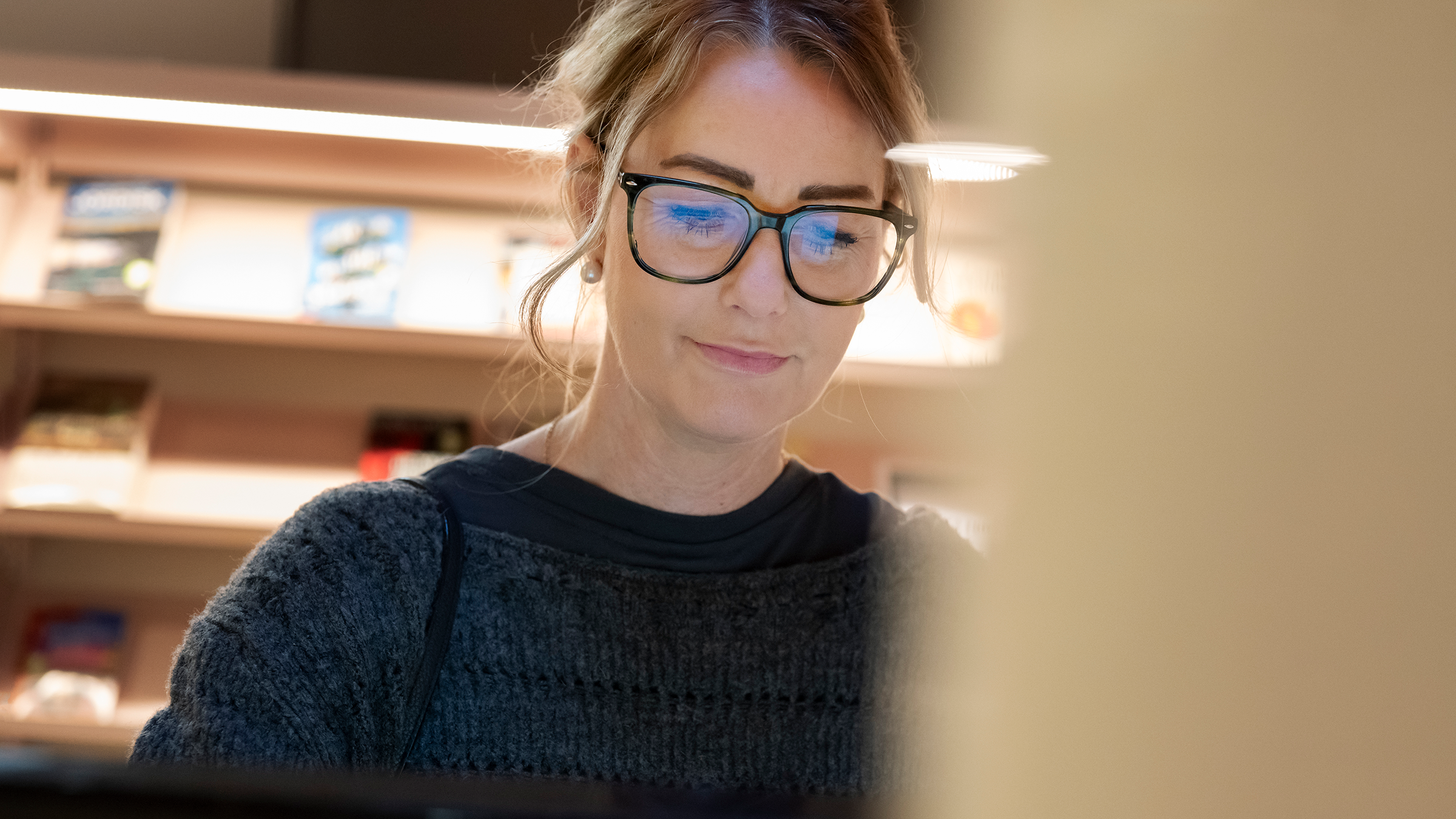 Kvinna står framför en dator