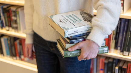 Person håller i böcker