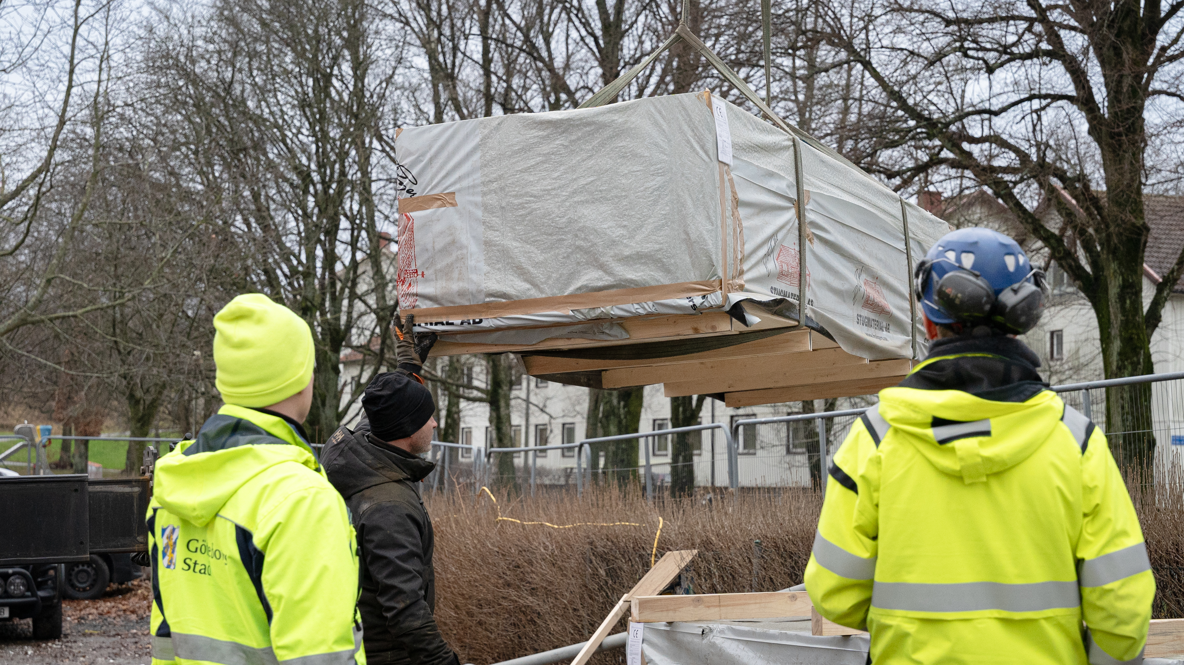 Ett lass med virke lossas på en byggarbetsplats