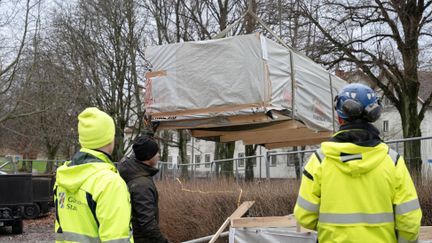 Ett lass med virke lossas på en byggarbetsplats