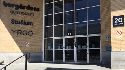 Huvudentrén till Burgårdens gymnasium ligger i hörnet, några trappsteg upp från gatan. Det är en glasentré som är två våningar hög. 