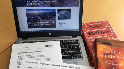 En bärbar dator, ett par böcker och stenciler, exempel på studiematerial inför en prövning. 