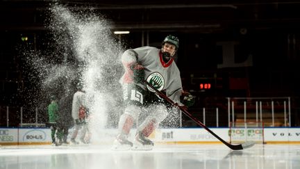 Elev i ishockeymundering i en rink.