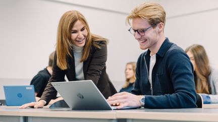 Foto på en lärare som hjälper en elev med ett skolarbete. Foto av Welcom