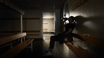 Foto på en elev som dricker vatten i ett omklädningsrum. Foto av Frank & Earnest