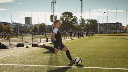 Foto på en fotbollsspelare som sparkar en fotboll. Foto av Frank & Earnest