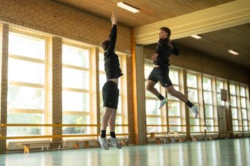 Två handbollsspelare i skolans idrottshall. Foto av Valentin Experience