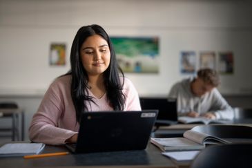 Elever som arbetar med skoluppgifter i ett skolklassrum. Foto av Valentin Experience