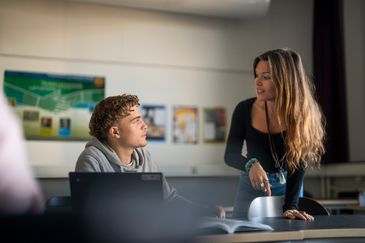 Foto på en lärare som instruerar en elev i ett skolklassrum. Foto av Valentin Experience