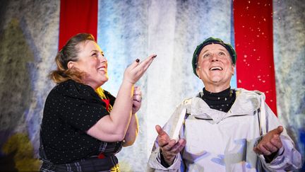 Två personer som håller upp händerna i luften och fångar snöflingor.