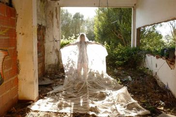 Foto av en person som står i solskenet i ett övergivet hus