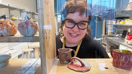 Foto av en person i en keramikstudio som ler och tittar in i kameran