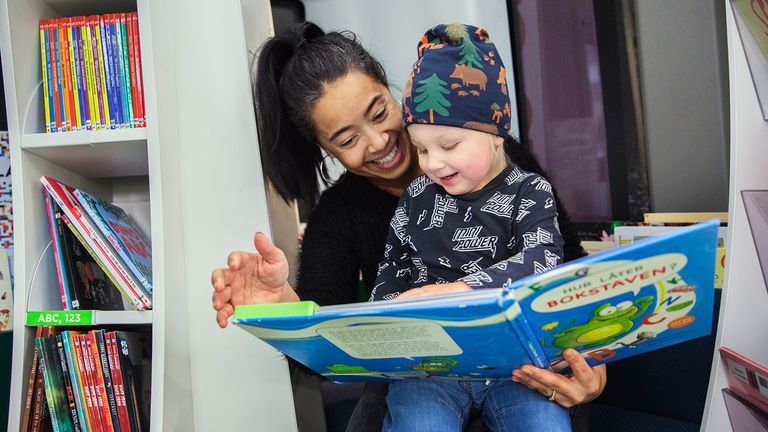 Kvinna och barn som läser en bok tillsammans