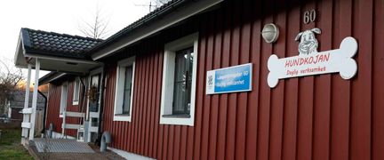 En röd träfasad med skylten Hundkojan.