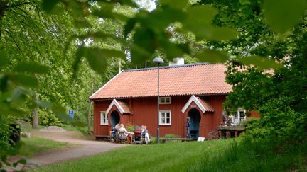 Rött trähus med tegeltag.