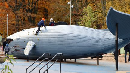 Blå val gjord av träd som barn leker på.