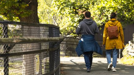 Två besökare går längst med ett av djurhägnen i Slottsskogen.