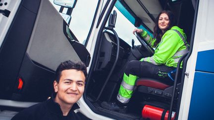 En elev som sitter i och en elev som står utanför en lastbil. 