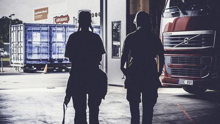 Elever i motljus i verkstadsmiljö. 