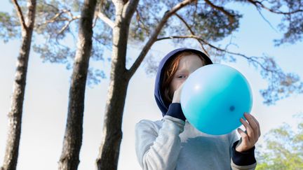 Pojke som blåser upp en ballong