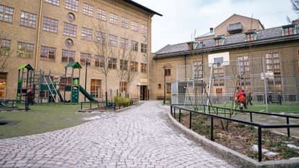 En översikt av Karl Johansskolan med en lekplats och några personer i bakgrunden. 