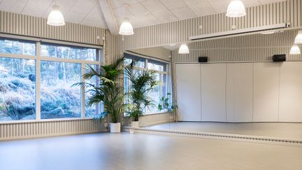 sal med stort glasparti mot skog