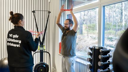 Instruktör och besökare använder gummiband för träning