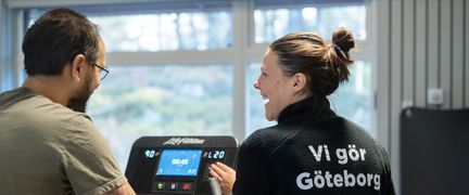 Personal och besökare skrattar vid en motionscykel