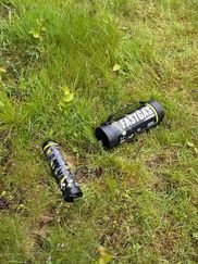 Svarta lustgastuber som ligger slängda i gräset.