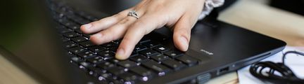 En hand skriver på ett tangentbord.