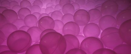 Ett bollhav med upplysta lila bollar.