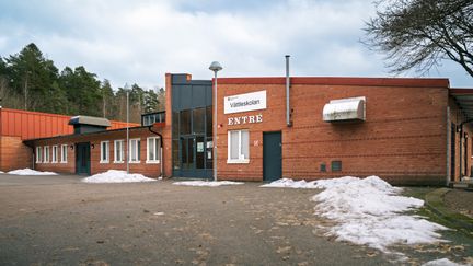 Vättleskolans huvudentré med en skog i bakgrunden.
