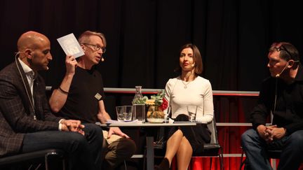 Four people on the Freedom of Expression stage at Gothenburg Book Fair. One is holding up the book 