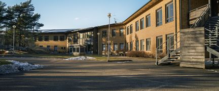 En tom skolgård framför en skolbyggnad i tegel.
