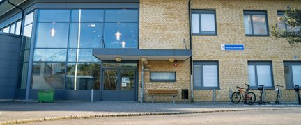 En skolbyggnad med en entré och en liten skylt på fasaden med texten Nordlyckeskolan