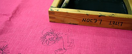 Ett rosa tyg med svart textiltryck av ett lejon.