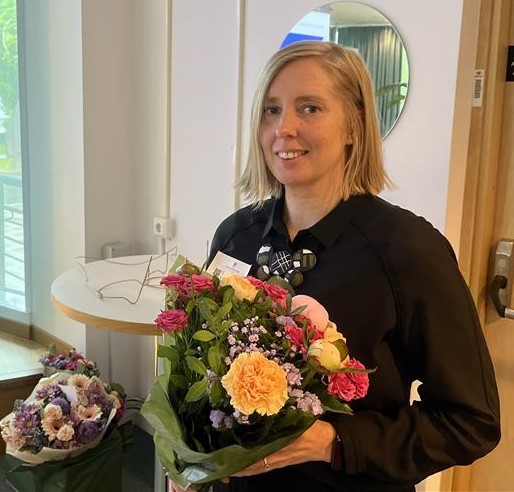 Lina Engvall står med en stor blomsterbukett i sina händer efter föreläsningen. 
