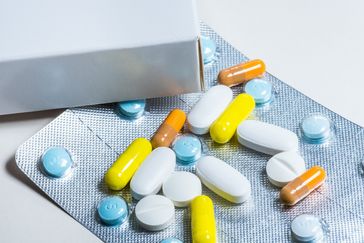 En tablettkarta med lösa mediciner runt om.