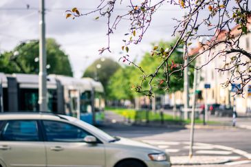 En bil och spårvagn i stadsmiljö