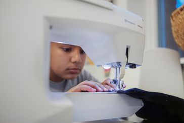 En person syr på symaskin