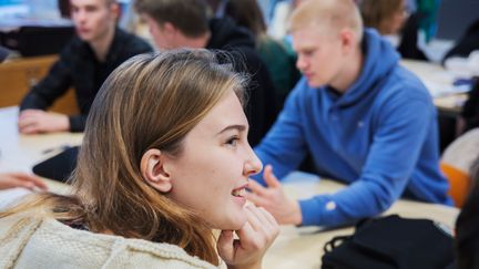 Gymnasieelever sitter runt ett bord