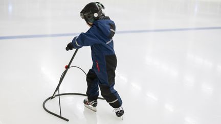 Ett barn som åker skridskor med åkstöd