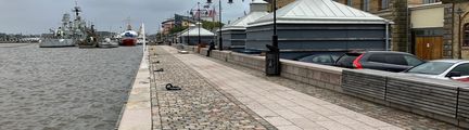 Högvattenskydd i form av långa låga stenbänkar längs Packhuskajen.